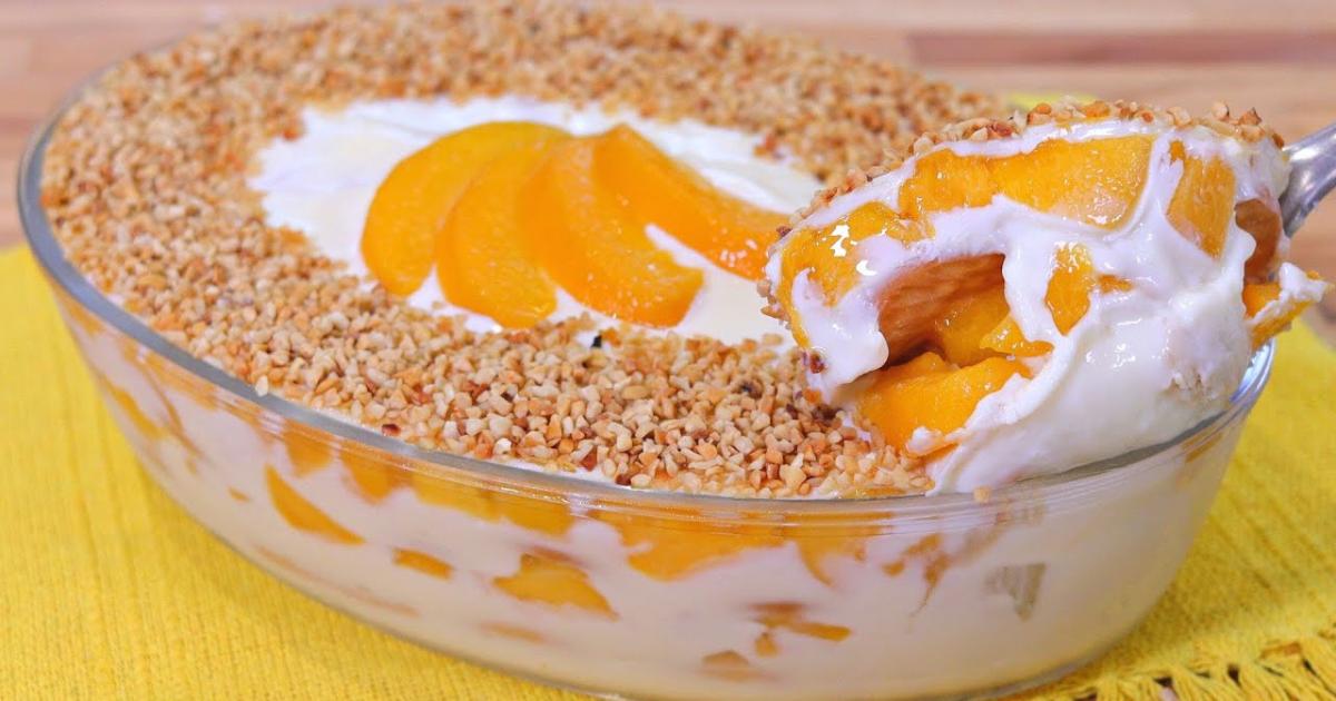 Pavê de pêssego com creme leve, bolachas molhadas e decoração de frutas e castanhas....