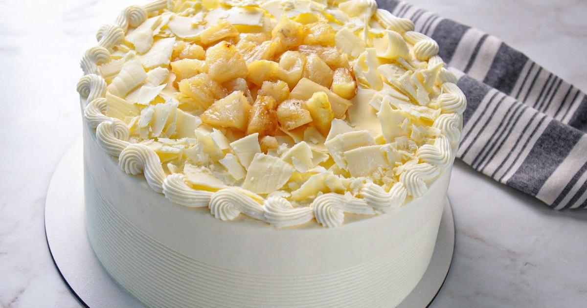Bolo de abacaxi recheado com creme suave, perfeito para vitrine ou datas especiais....