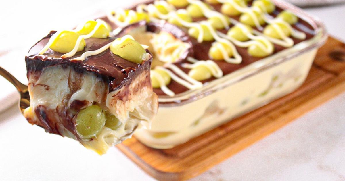 Sobremesa gelada com uvas, creme branco e ganache de chocolate....